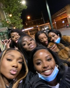 a group of young women standing next to each other on the side of a road