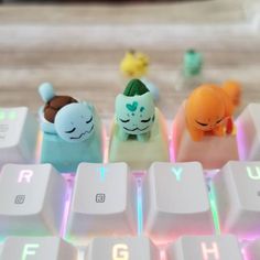 three small toy animals sitting on top of a computer keyboard with their heads turned to look like they are sleeping