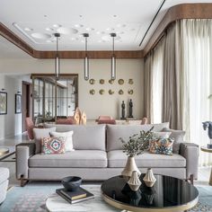 a living room filled with lots of furniture next to a large window covered in curtains