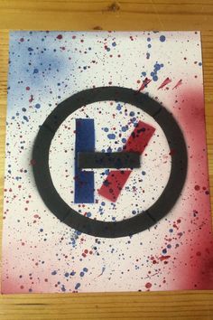 a circular sign with red, white and blue paint splattered on the surface