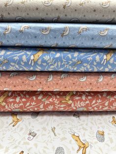 four different fabrics are stacked on top of each other, with animals and stars in the background