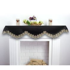 a white fireplace with a black table cloth on it