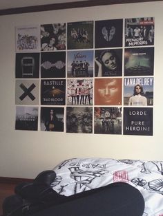 a bedroom with posters on the wall and a black suitcase sitting in front of it