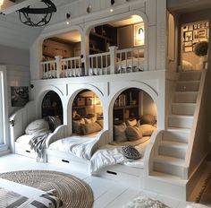 a bedroom with bunk beds built into the wall and stairs leading up to it's second floor