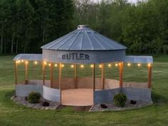 a round structure with lights on it in the middle of a field