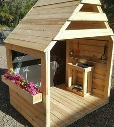 an outdoor kitchen made out of wooden pallets with flowers in the potting area