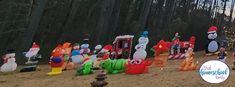 there are many inflatable snowmen and christmas trees on the beach with people standing around them