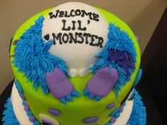 a green and blue cake with the words welcome lil monster on it's side