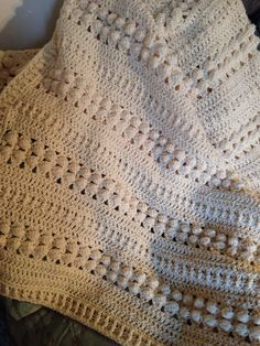 a crocheted blanket sitting on top of a bed