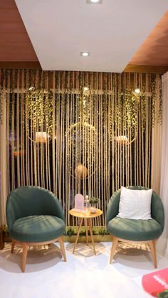 two green chairs sitting next to each other in front of a window with curtains on it