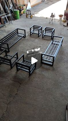 a group of black benches sitting on top of a cement floor