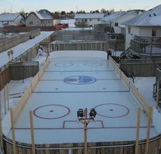 an outdoor ice rink in the middle of winter with snow on the ground and fence around it