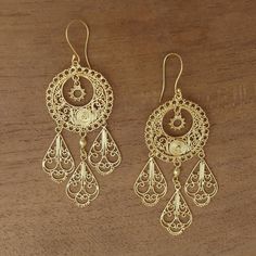 Possessing the elegance of a princess these chandelier earrings are designed by Balinese artisan Desi Antari. Handcrafted sterling silver wire and dot patterns are bathed in 18k gold with three sections that dangle below. Ornate Yellow Gold Chandelier Dangle Earrings, Ornate Yellow Gold Dangle Chandelier Earrings, Yellow Gold Chandelier Earrings With Sterling Silver, Yellow Gold Chandelier Earrings With Intricate Design, Pierced Yellow Gold Sterling Silver Chandelier Earrings, Ornate Chandelier Earrings With Ear Wire, Gold Filigree Sterling Silver Chandelier Earrings, Yellow Gold Filigree Dangle Chandelier Earrings, Gold Sterling Silver Filigree Chandelier Earrings