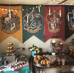 there are many harry potter banners hanging above the dessert table