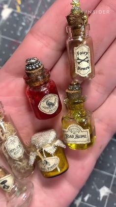 miniature bottles filled with different types of liquid in the palm of someone's hand