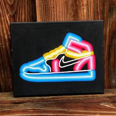 a painting of a pair of sneakers on a black background with wooden planks behind it