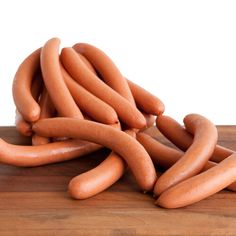 a pile of hot dogs sitting on top of a wooden table