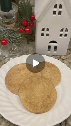 a white plate topped with three pancakes on top of a counter next to a house