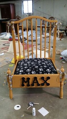 a wooden bed frame with the word max on it in front of other furniture items