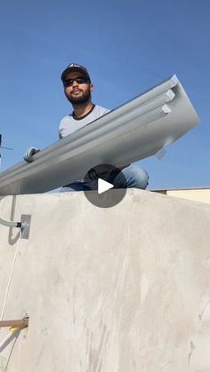 a man sitting on top of a cement structure