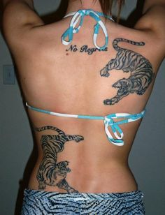 the back of a woman with tattoos on her body and two tigers tied to it