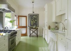 a kitchen with white cabinets and green flooring in the center, along with stainless steel appliances