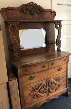 an old wooden dresser with a mirror on it's top and some drawers below