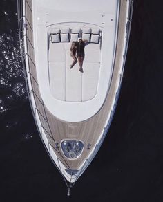 an aerial view of a boat in the water with two people on it's back