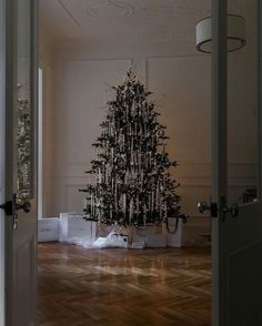 a small christmas tree is in the middle of a room with boxes on the floor