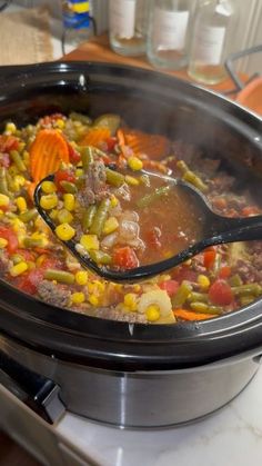 a spoon full of soup sitting on top of a stove