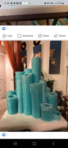 blue glass vases are stacked on top of each other in the middle of a room