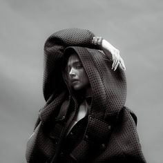 a woman in a hooded jacket is posing for the camera