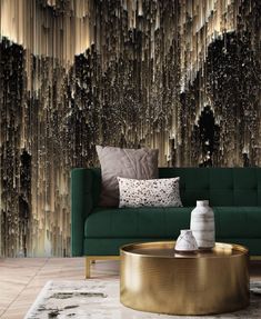 a green couch sitting in front of a wall covered in brown and black paint splatters