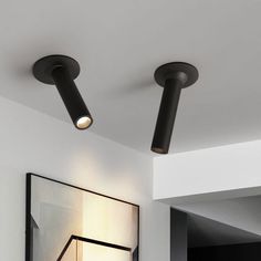 two lights that are on the ceiling in a room