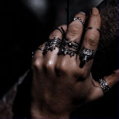 a person with rings on their fingers holding something