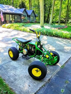 a green and yellow four wheeled vehicle parked in front of a house