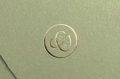 the letter e is inscribed in a circle on top of a piece of green paper