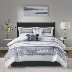 a bed with white and blue comforters in a bedroom