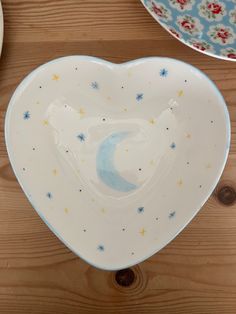 two heart shaped dishes sitting on top of a wooden table