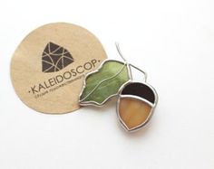 two leaf shaped brooches sitting next to each other