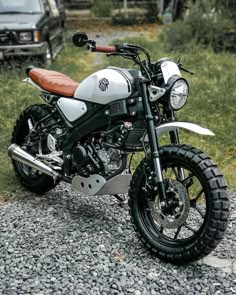 a white and black motorcycle parked on gravel