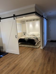 an open door leading to a bedroom with a bed in the corner and a closet behind it