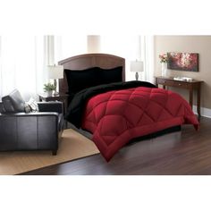 a red and black comforter on a bed in a room