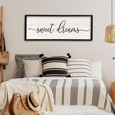 a bedroom with a bed, pillows and a hat on the headboard that says sweet dreams