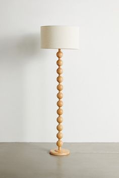 a lamp that is on top of a table next to a white wall and floor