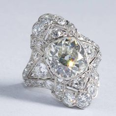 an antique diamond ring is shown on a white surface with the center stone surrounded by smaller diamonds