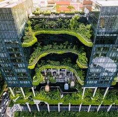 an aerial view of a city with lots of trees and plants on the top floor