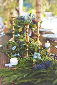 the table is set with candles and greenery