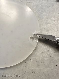 a pair of scissors cutting through a piece of clear plastic on top of a table