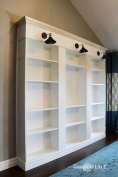 an empty bookcase in the corner of a room with blue carpet and white walls